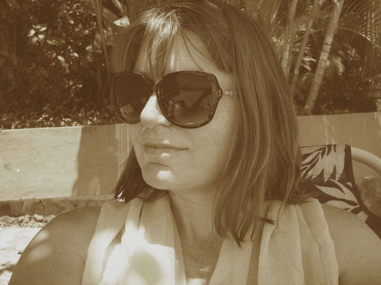 Sepia toned photo of author Rose Hunter wearing sunglasses in Puerto Vallarta, Mexico